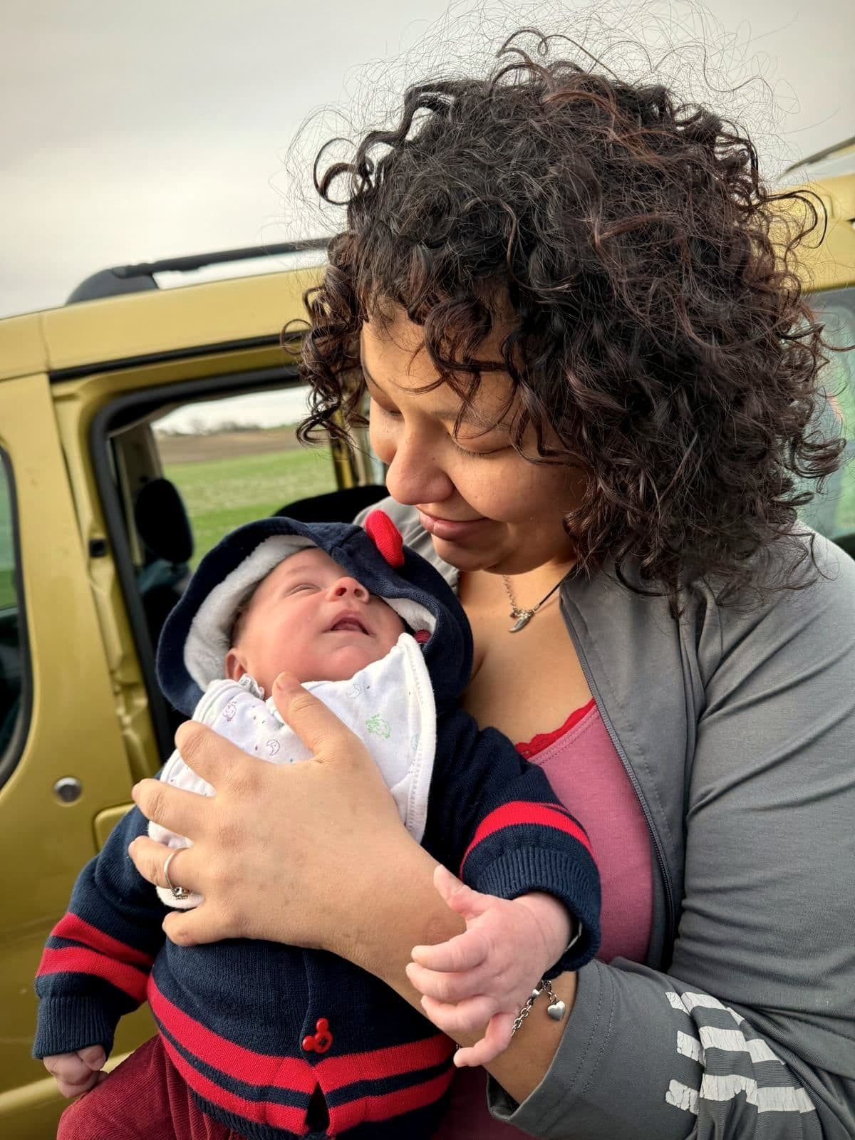 Une maman accueillie tient son nouveau-né dans ses bras et le regarde.